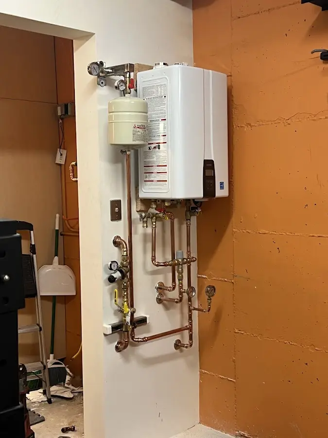 Plumbing technician inspecting water heater connections in Duanesburg